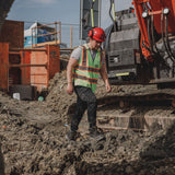 Worker wearing Amblers FS32 safety boots on muddy construction site with full PPE and hi-vis vest