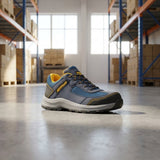 Blue and gray work shoe with yellow accents on a warehouse floor.