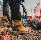 Caterpillar Striver XL S7 tan safety boots worn on muddy construction site with cables